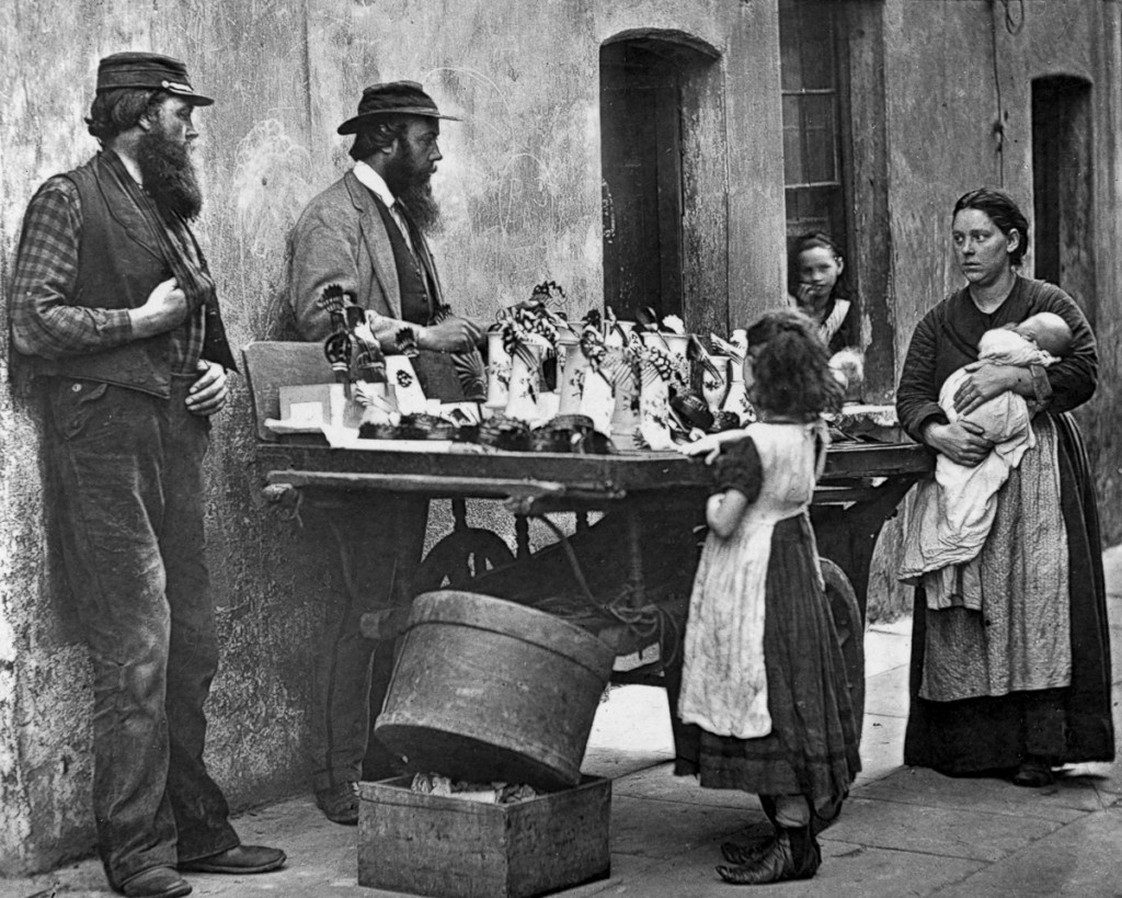 A Victorian fancy wear dealer selling ornaments from his barrow. Original Artwork: From 'Street Life In London' by John Thomson and Adolphe Smith - pub. 1877 